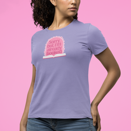 Woman wearing a purple t-shirt with a pink graphic and text on a pink background