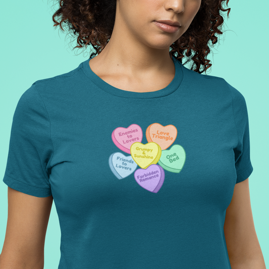 Person wearing a teal t-shirt with colorful candy hearts design on a turquoise background